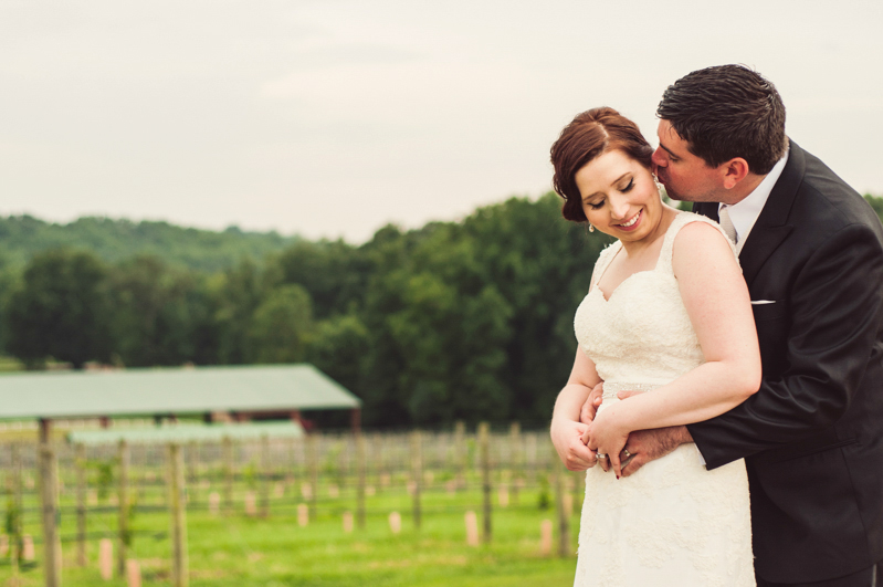 wedding couple kiss in front of vineyard
